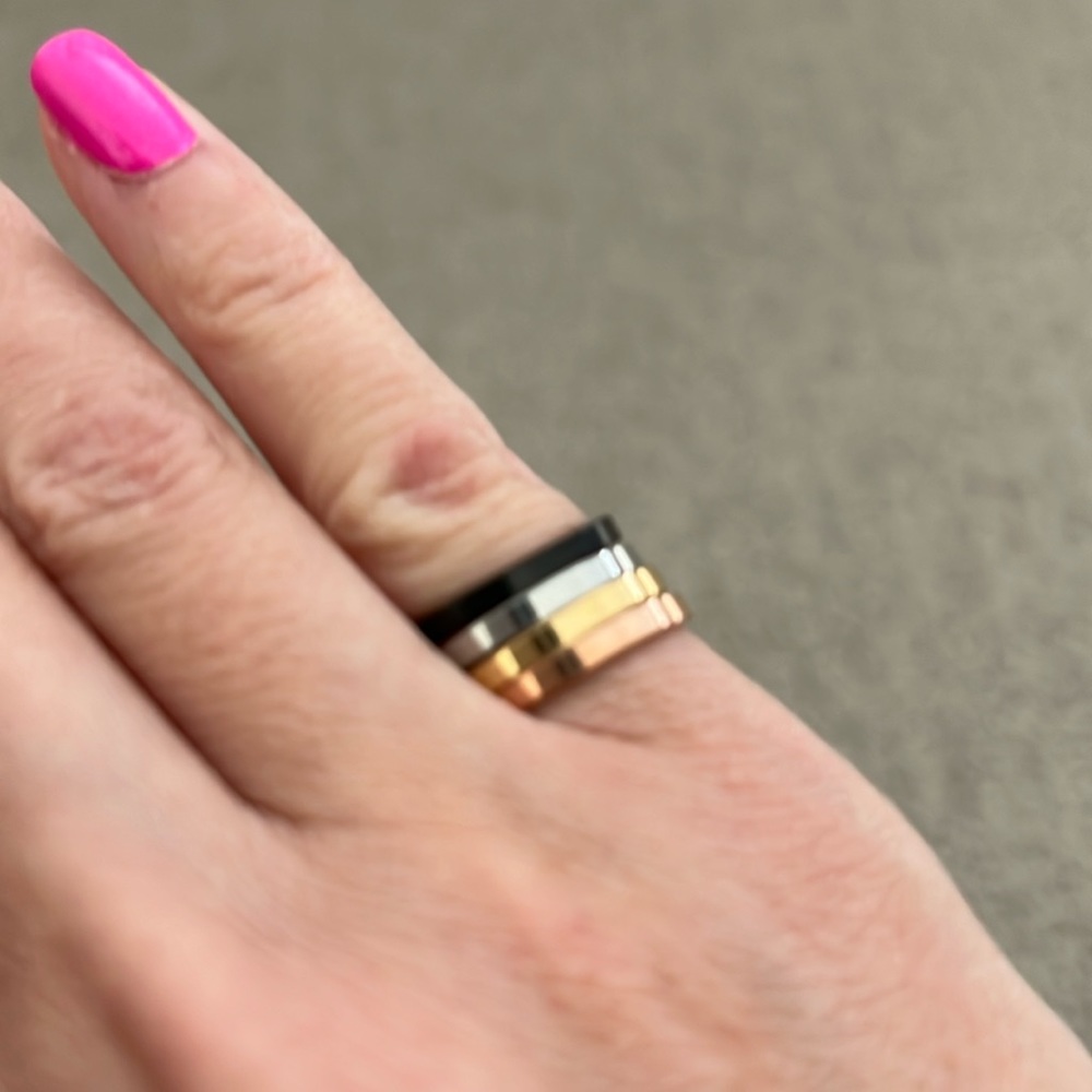 Set of 4 stackable steel rings. Size 5. Black, silver, yellow gold & rose gold.